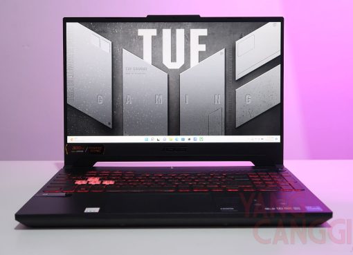 A sleek TUF Gaming laptop with its lid open, showcasing its vibrant RGB keyboard and rugged design, ready for action on a dark, minimalist desk setup, highlighting the blend of performance and durability.