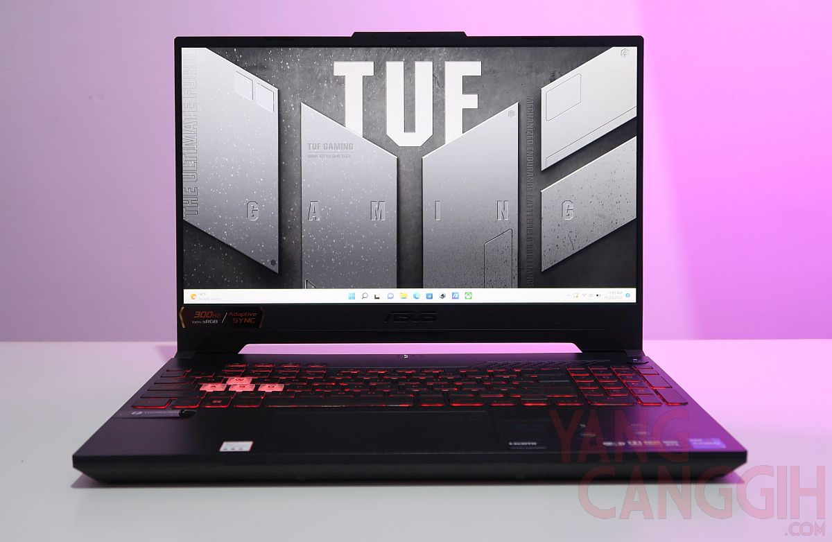 A sleek TUF Gaming laptop with its lid open, showcasing its vibrant RGB keyboard and rugged design, ready for action on a dark, minimalist desk setup, highlighting the blend of performance and durability.